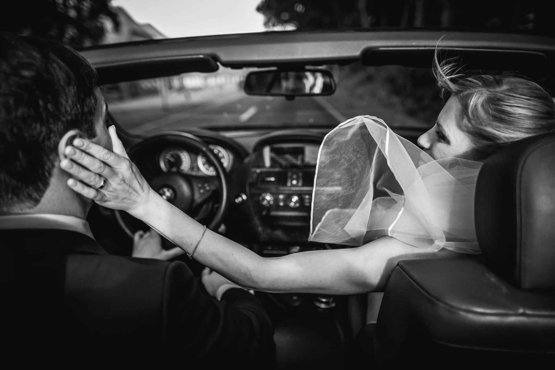 Das Brautpaar sitzt im Cabrio auf dem Weg zur Hochzeitslocation bei Leipzig. Fotografiert während der Fahrt