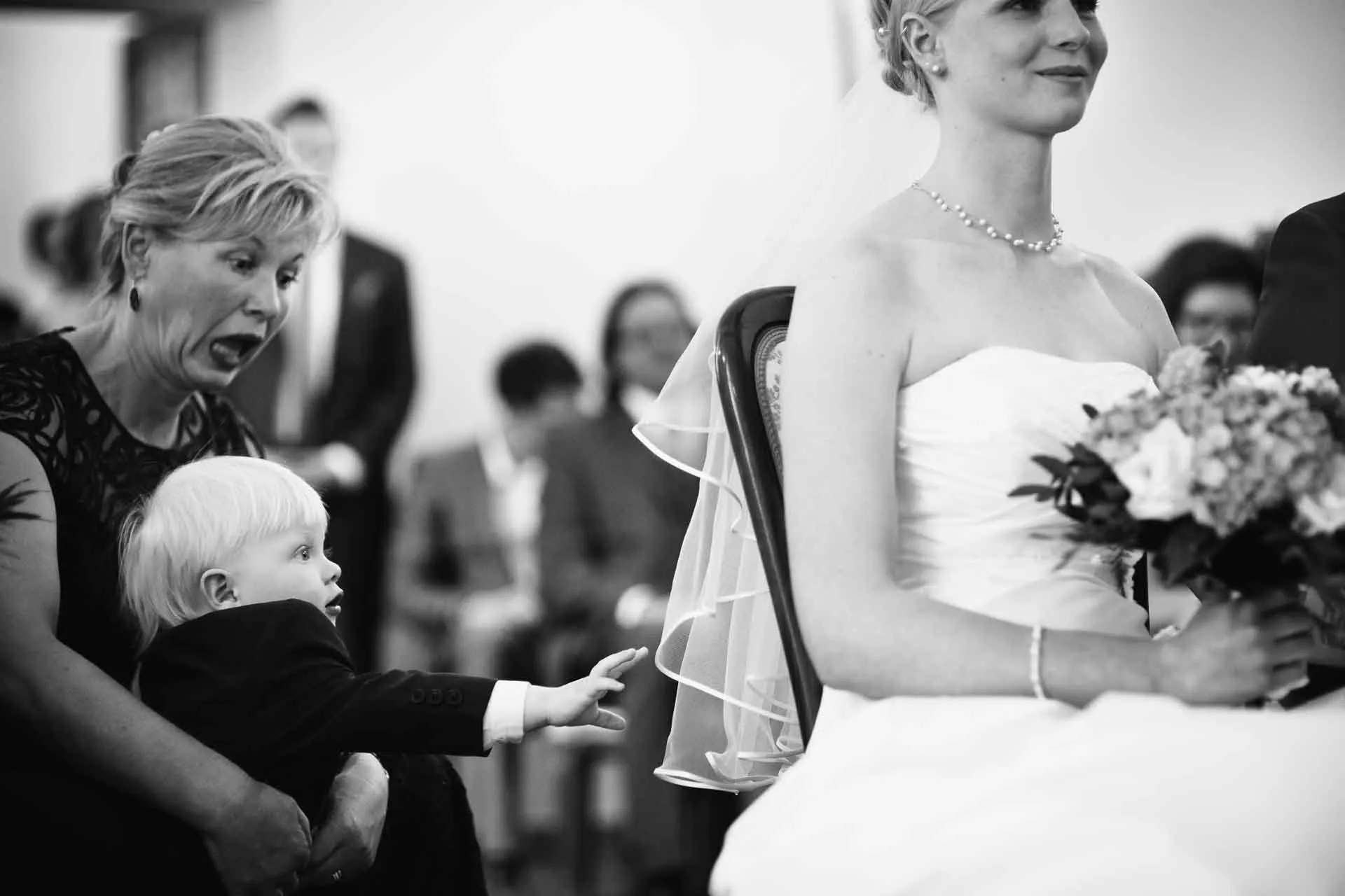 Hochzeitsreportage während der Trauung. Das Kind versucht, den Schleier zu greifen.