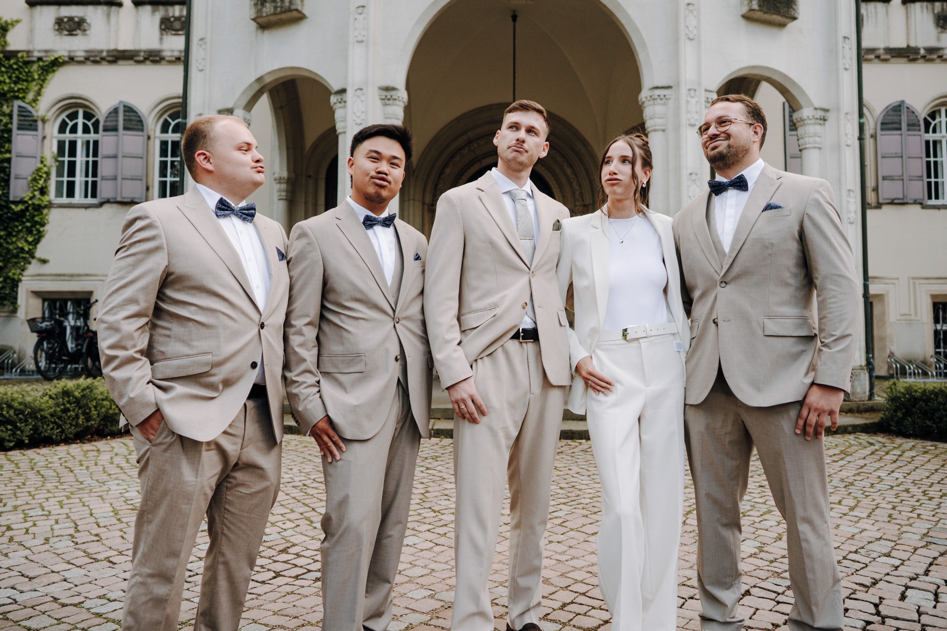 Das Brautpaar im Gruppenfoto mit den Trauzeugen vor der Fassade von Schloss Waldenburg.