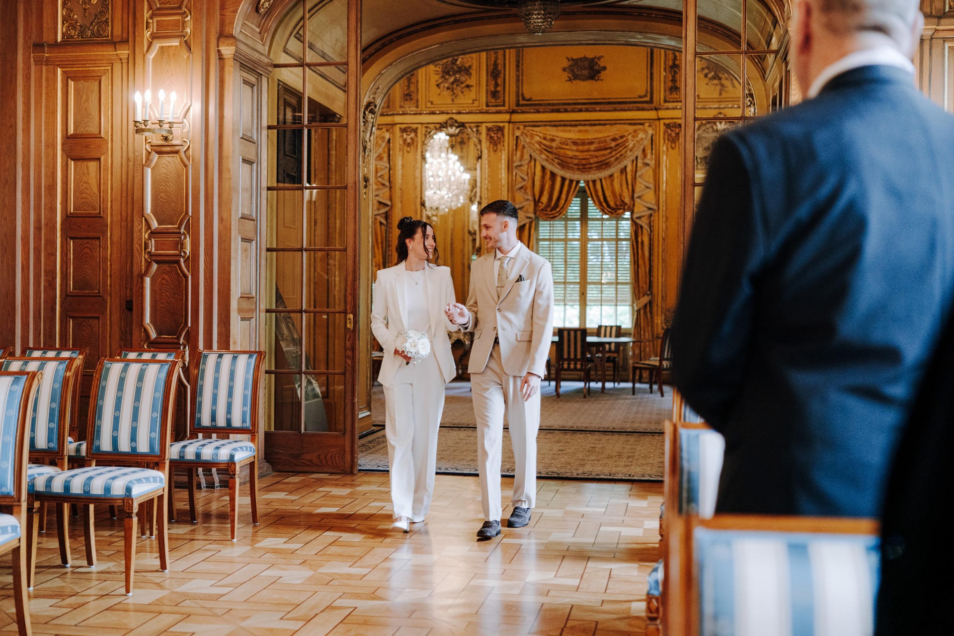 Melissa und Lukas gehen gemeinsam durch einen historischen Saal im Schloss Waldenburg.