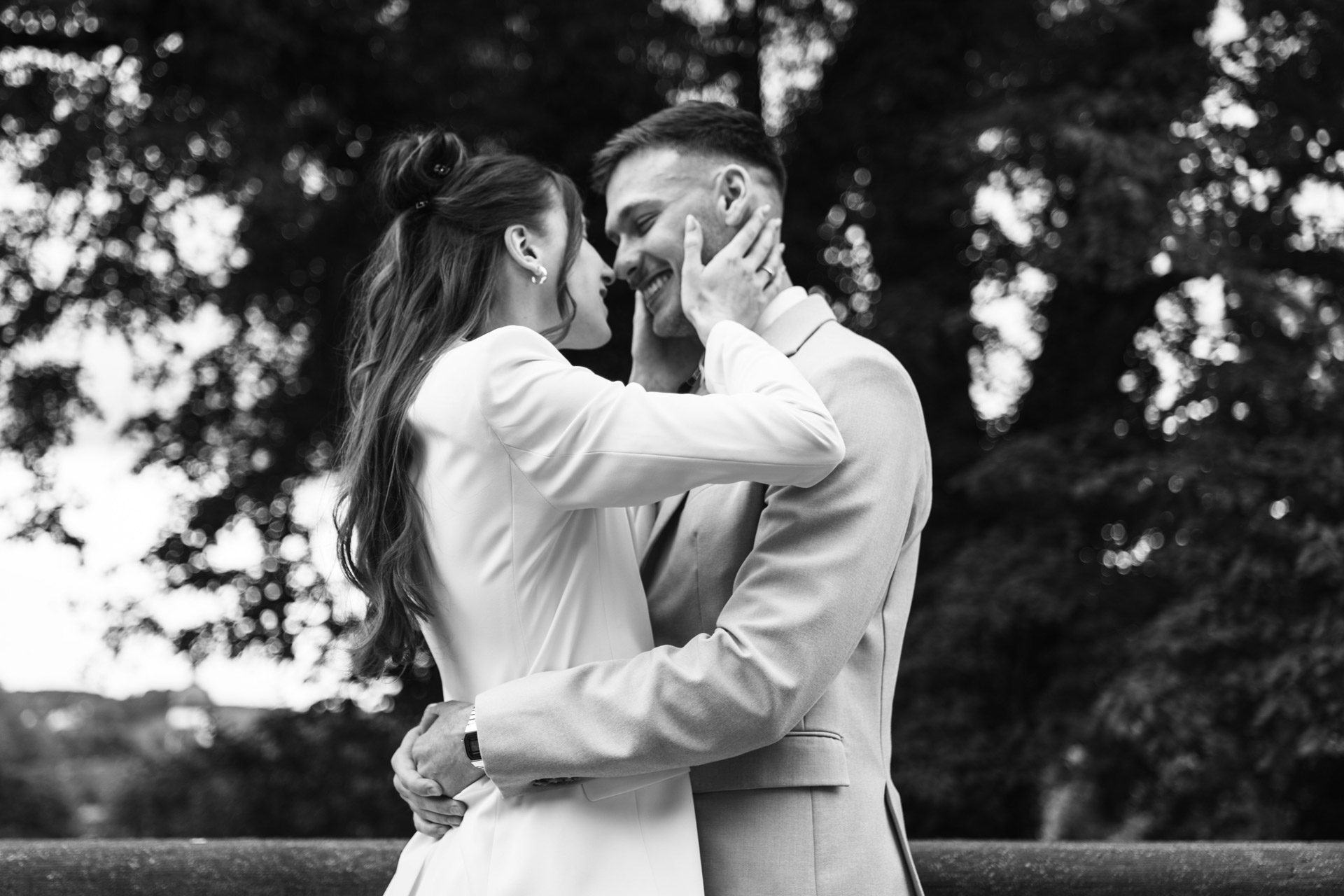 Schwarz-Weiß-Aufnahme von Melissa und Lukas bei einer innigen Umarmung im Freien.