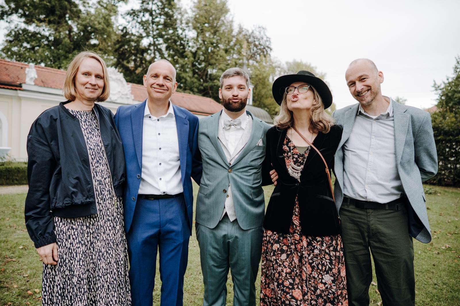 Jonas steht mit vier Hochzeitsgästen für ein Gruppenbild im Garten zusammen.